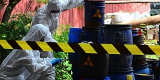 两位亚洲科学家通过鉴定危险的化学物质而穿上防护服