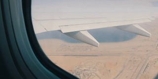 飞机正在沙漠上空飞行。一架飞机在沙漠的黄色背景下飞出窗外