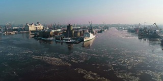 全景式的工业区周围的北港河上覆盖着冰，码头的起重机和商业船只