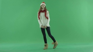 迷人的年轻美丽在圣诞帽走和看周围，色度键的背景视频素材模板下载