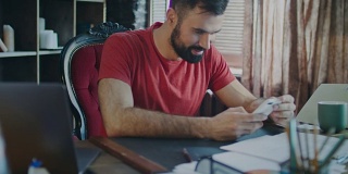 年轻的商人在家庭办公室用笔记本电脑工作。现代经理