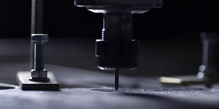 该公司的机器人在编写的与钢工作的程序的帮助下，用钻头慢动作地从铝板上切割下来。金属刨花向不同的方向飞行