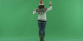 戴着圣诞帽的严肃年轻女子在虚拟环境中从背后做手势，背景上有色度键