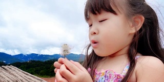 little girl blowing flower slow motion