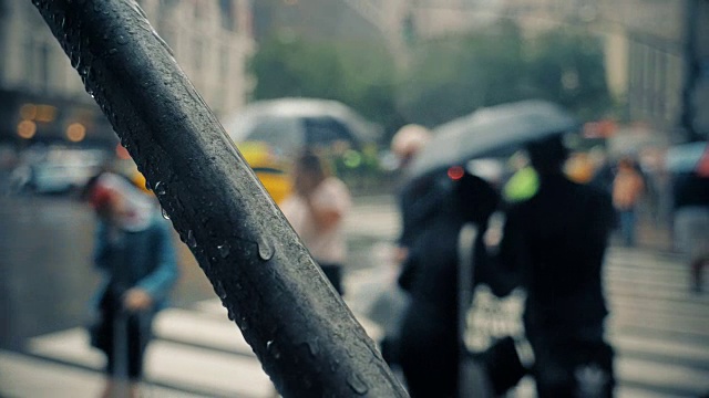 慢镜头下的行人撑着雨伞在曼哈顿下雨的街道上