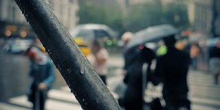 慢镜头下的行人撑着雨伞在曼哈顿下雨的街道上