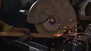 在工厂里，工人正在用圆盘抛光机打磨金属梁的边缘视频素材模板下载