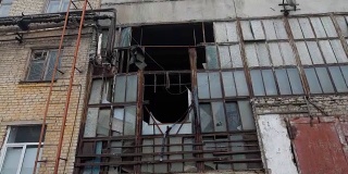 阴天拆除旧工业建筑外立面，玻璃破碎，框架被毁