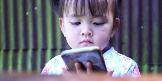 特写——小女孩在玩数字智能手机