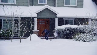 在家门口铲雪的男人视频素材模板下载