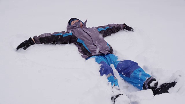 男孩做雪天使