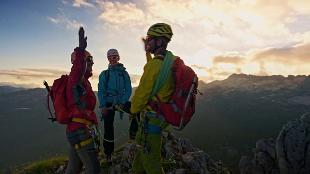 三人登山队在日落时到达山顶