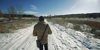 一个人走在乡下的雪地上