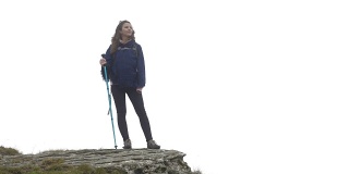 快乐的登山家年轻女子的特写被雾包围站在山顶看远处的风景
