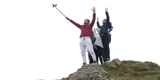 一群兴奋的游客在山顶自拍庆祝友谊和自由