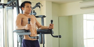 年轻的亚洲健美男在健身房锻炼腹肌，健康的生活理念