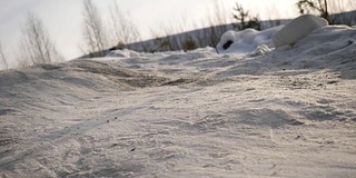 男性的腿在冬天的鞋子走在雪地上的特写。在冬天穿着雪鞋和钉鞋走在雪地上的景象。穿靴子的男人们的腿挡住了白雪覆盖的小路