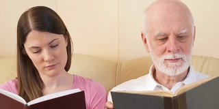 父亲和女儿阅读纸质书。传统古典读本的概念