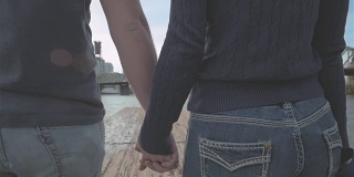 日落时分，一对年轻的恋人在码头上散步时拥抱在一起