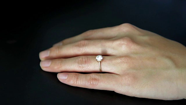 从无名指上取下订婚戒指。离婚观念，婚姻问题。