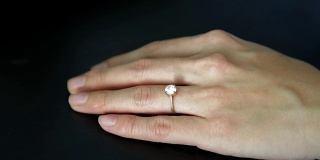 从无名指上取下订婚戒指。离婚观念，婚姻问题。