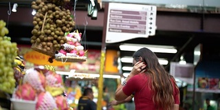 年轻女子在当地市场购物