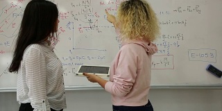 女同学在白板前写数学公式