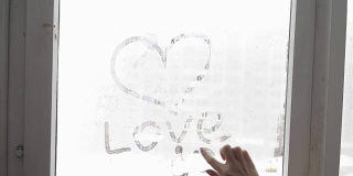 手画爱的心在冷雾蒙蒙的窗户背景，特写图像。