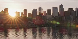 日出时，太阳从西雅图市中心的建筑物后面探出头来。