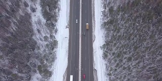 空中景观车在冬季高速公路上通过积雪的森林