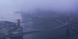 在雾蒙蒙的早晨，沿着东河飞过布鲁克林和曼哈顿大桥。