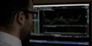 商人坐在电脑上，用电脑显示交易图形，股票交易所交易图形屏幕背景，商业金融和外汇概念。PC显示器显示模糊的饲料页。