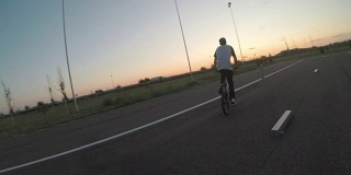 骑自行车的观点和他的十几岁的朋友在自行车上表演特技和特技在特殊的轨道自行车