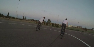 骑自行车的人与他的骑自行车的朋友玩各种翻筋斗和跳高的把戏