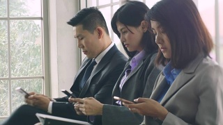 一群商务人士使用手机。视频素材模板下载