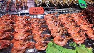 街头交易食品:在泰国夜市的烤肉串上炸虾视频素材模板下载