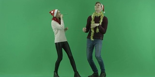 年轻快乐的夫妇庆祝圣诞节和跳跃一起与色度键的背景