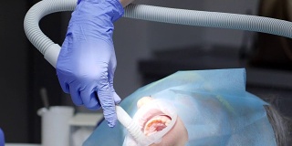 在医院做牙科手术，专家治疗病人的牙齿张开了嘴巴