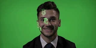 比特币加密货币符号投射在一个微笑的兴奋的商人投资者的脸上，背景是绿色的屏幕