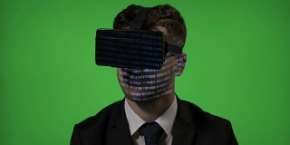 惊奇的男人业务经理体验VR虚拟现实眼镜阅读电脑编程代码在绿色屏幕上