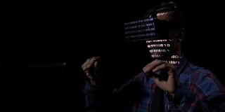 危险的黑客在他的藏身之处使用虚拟现实眼镜和全息图闯入政府系统并窃取数据