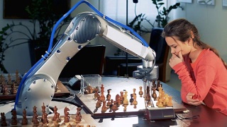 一个年轻的女孩用一个现代的自动国际象棋机器人移动棋子。4 k。视频素材模板下载