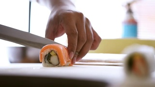 鱼块放在一卷米饭上炒。鲑鱼卷的准备视频素材模板下载