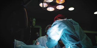 医生穿著防护服，使用消毒设备进行手术。医疗队在明亮的现代手术室进行外科手术。