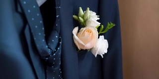 在婚礼当天，新郎夹克口袋里的胸花。夹。玫瑰在他的夹克口袋里