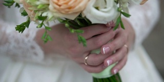新娘手里拿着漂亮的婚礼花束。夹。未婚妻穿着美丽的白色礼服，手里拿着一束由温柔的玫瑰制成的美丽的婚礼鲜花