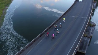一群骑自行车的人正在过桥的鸟瞰图。视频素材模板下载