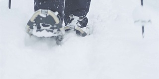 一个人的脚在雪天徒步旅行的特写镜头