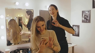 女发型师梳理着女发型师和看照片的发型在一起视频素材模板下载