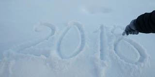 女人的手在白雪上写着2018